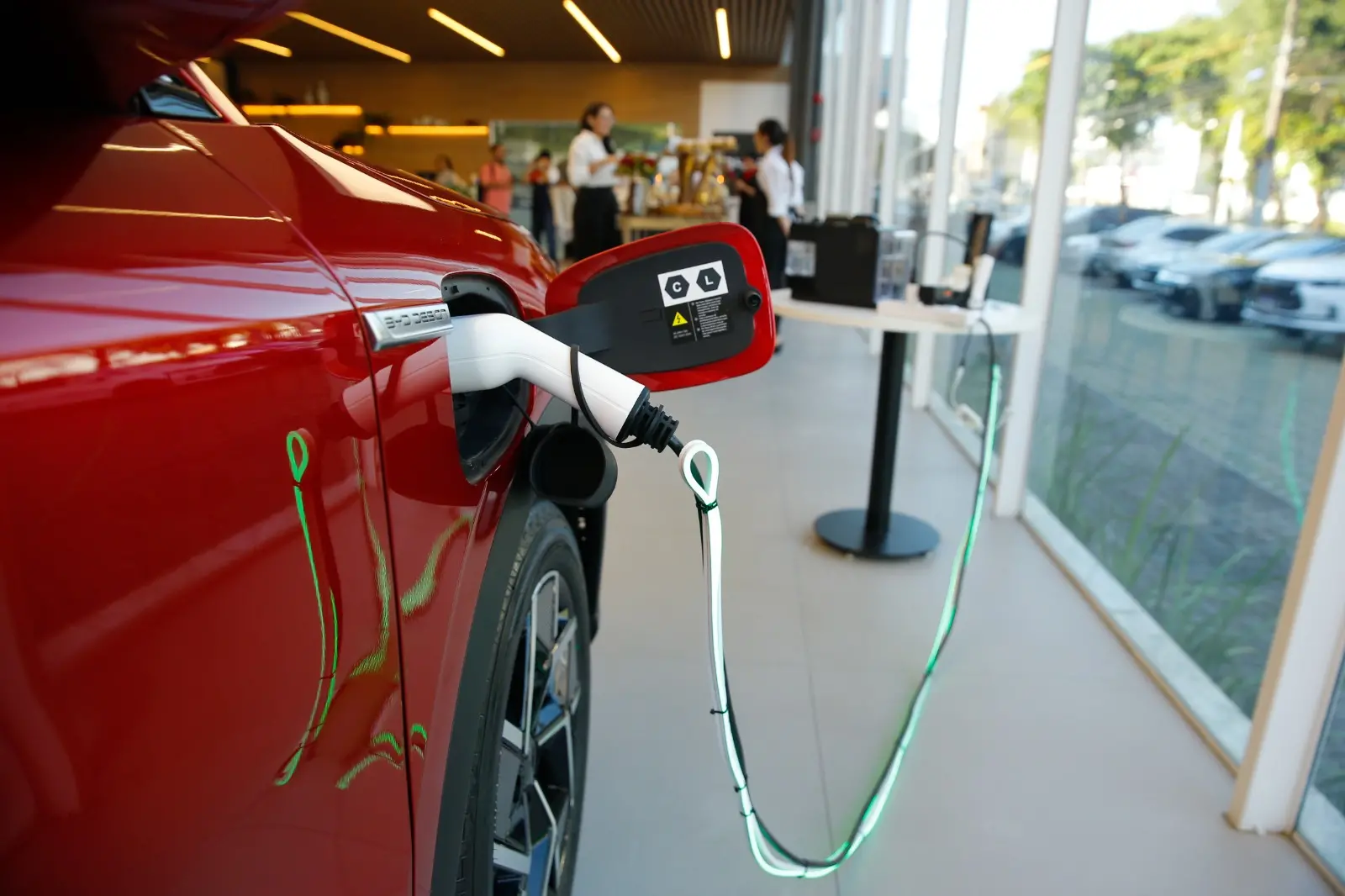 Carro elétrico BYD vermelho sendo abastecido.