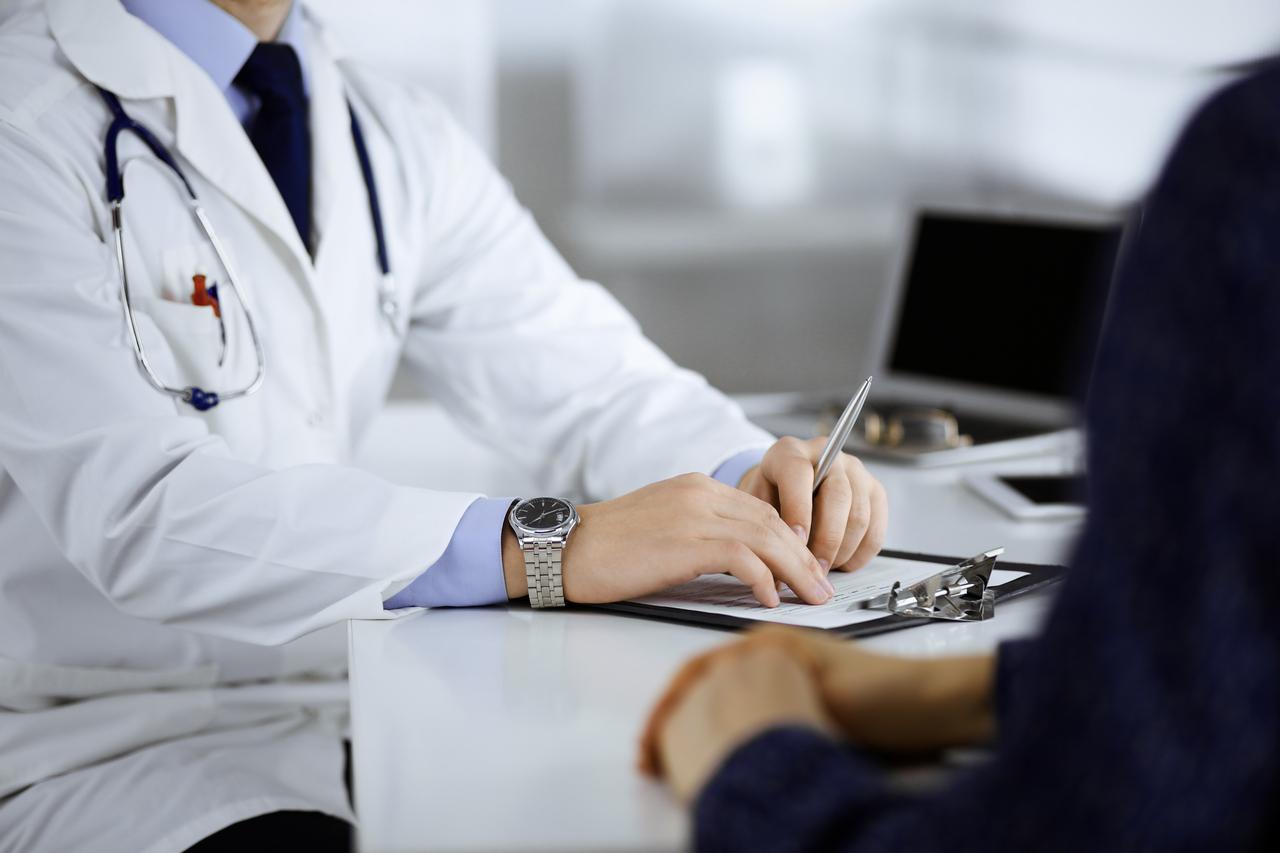 Imagem mostra close-up de mão de médico durante consulta