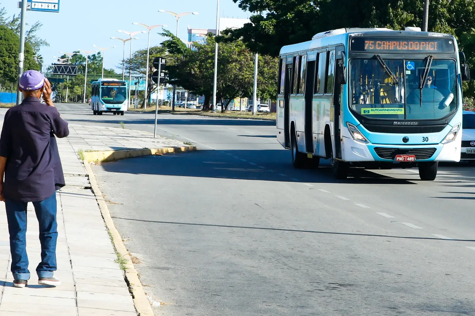 homem olha ônibus passando