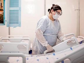 Enfermeira ajeita maca em hospital