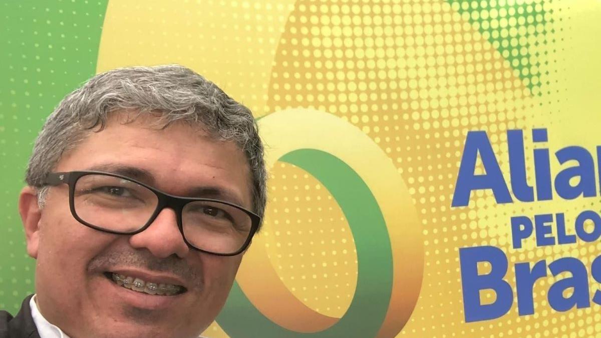 Wellington é um homem de meia idade e cabelos grisalhos. Na foto, ele está sorrindo, mostrando que usa aparelho nos dentes