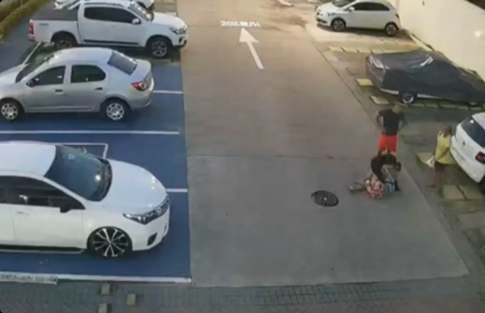 De pé, usando camiseta preta e bermuda vermelha, o investigador Raimundo Nonato Machado dá ordens para a esposa, Jussara, espancar a babá Claudia Gonzaga de Lima