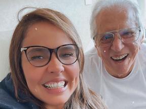 Renata e Carlos Alberto sorrindo. Os dois são brancos e usam óculos. Carlos tem os cabelos também brancos