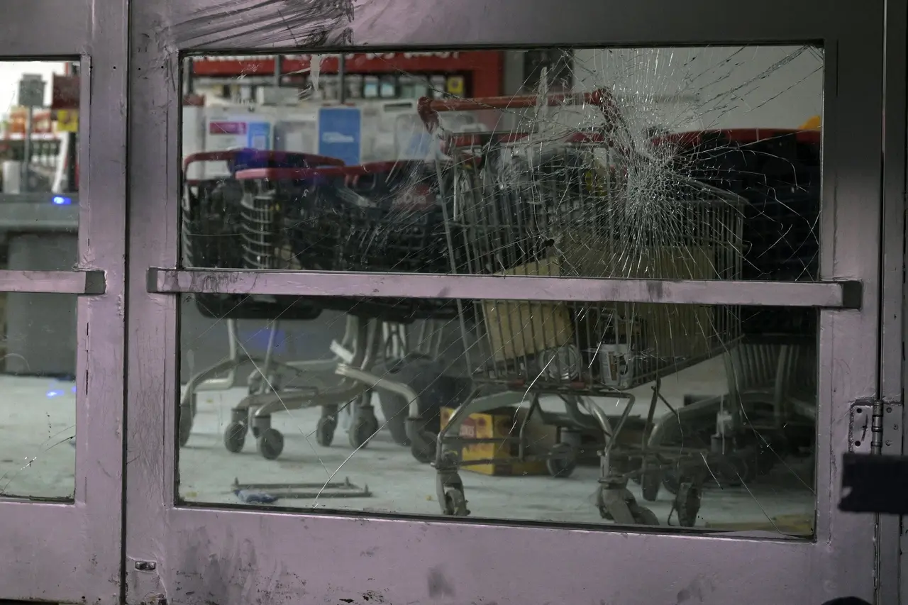 Foto do vidro quebrado da porta de um supermercado 