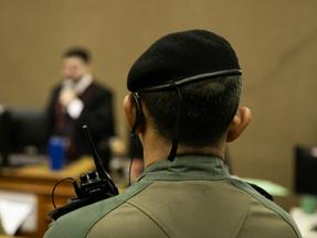 PM de costas sentado no banco dos réus durante julgamento da Chacina do Curió