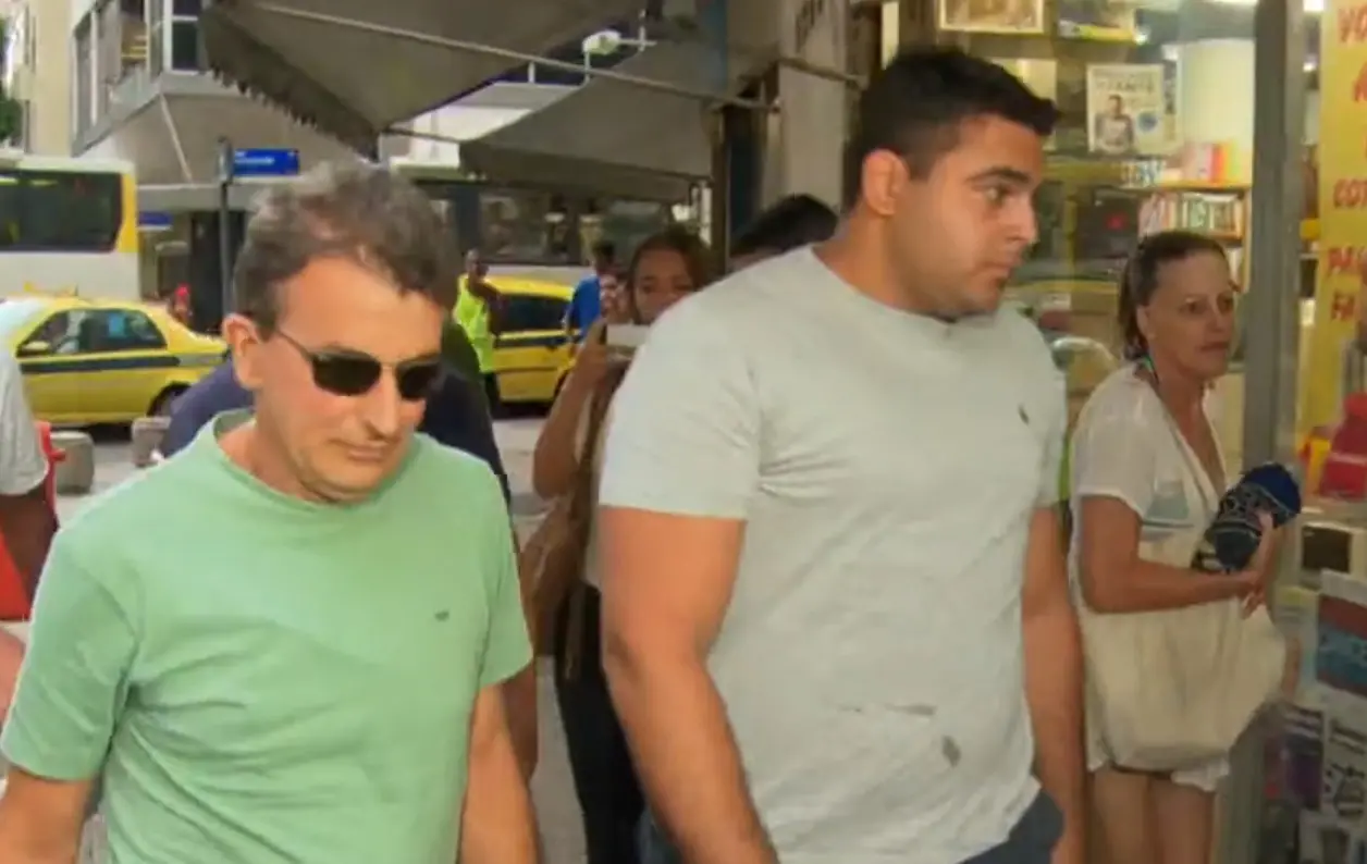 Rafael Bussamra e Roberto Bussamra caminhando em rua em direção à delegacia de polícia