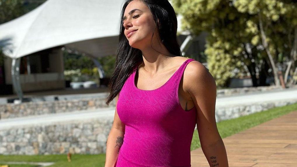 Bruna Biancardi grávida pegando na barriga e tomando sol com uma roupa rosa
