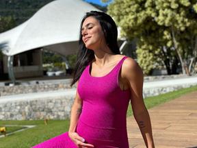 Bruna Biancardi grávida pegando na barriga e tomando sol com uma roupa rosa