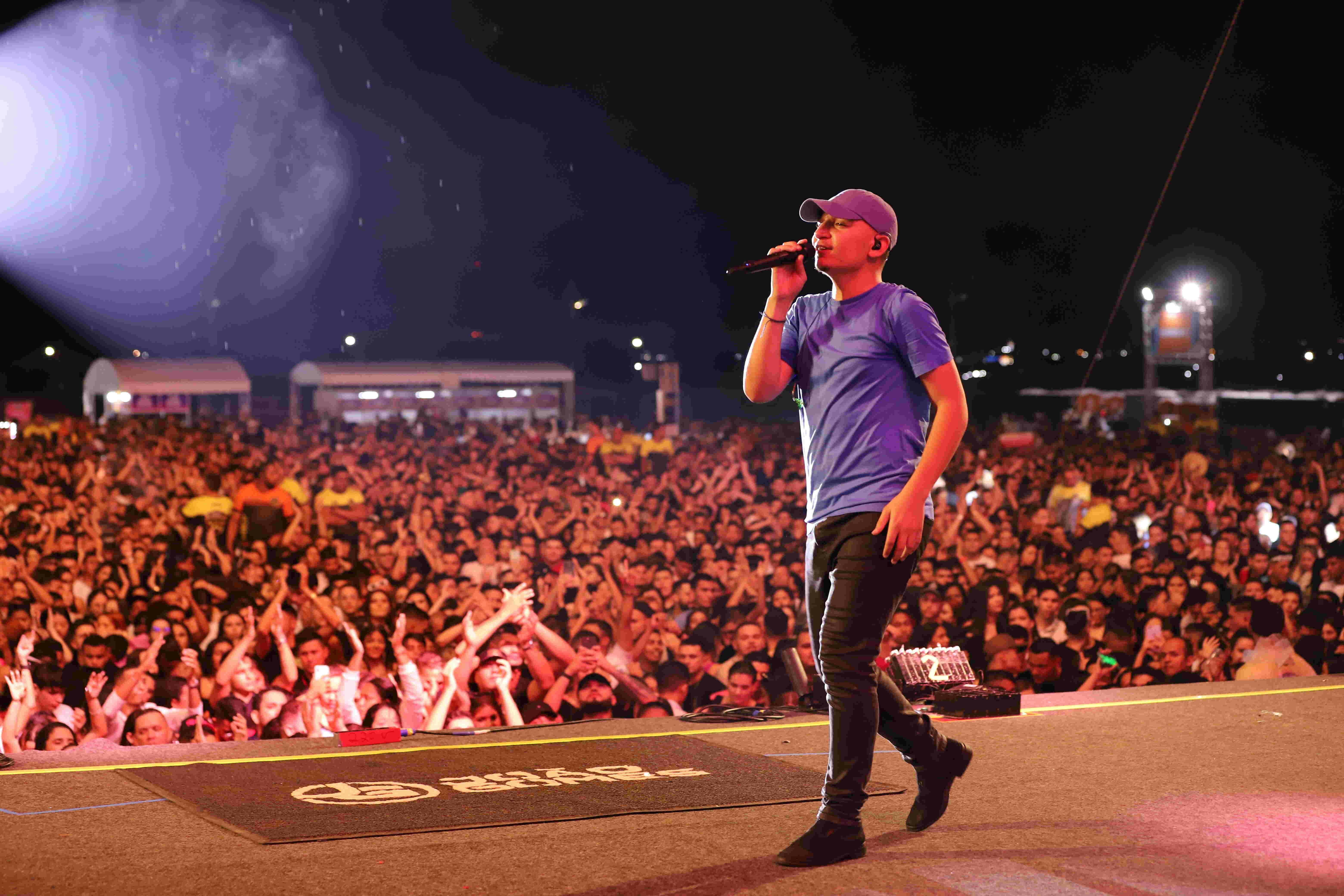 João Gomes andando no palco de evento com grande público destaque em foto