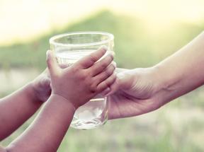 criança recebendo copo d'água
