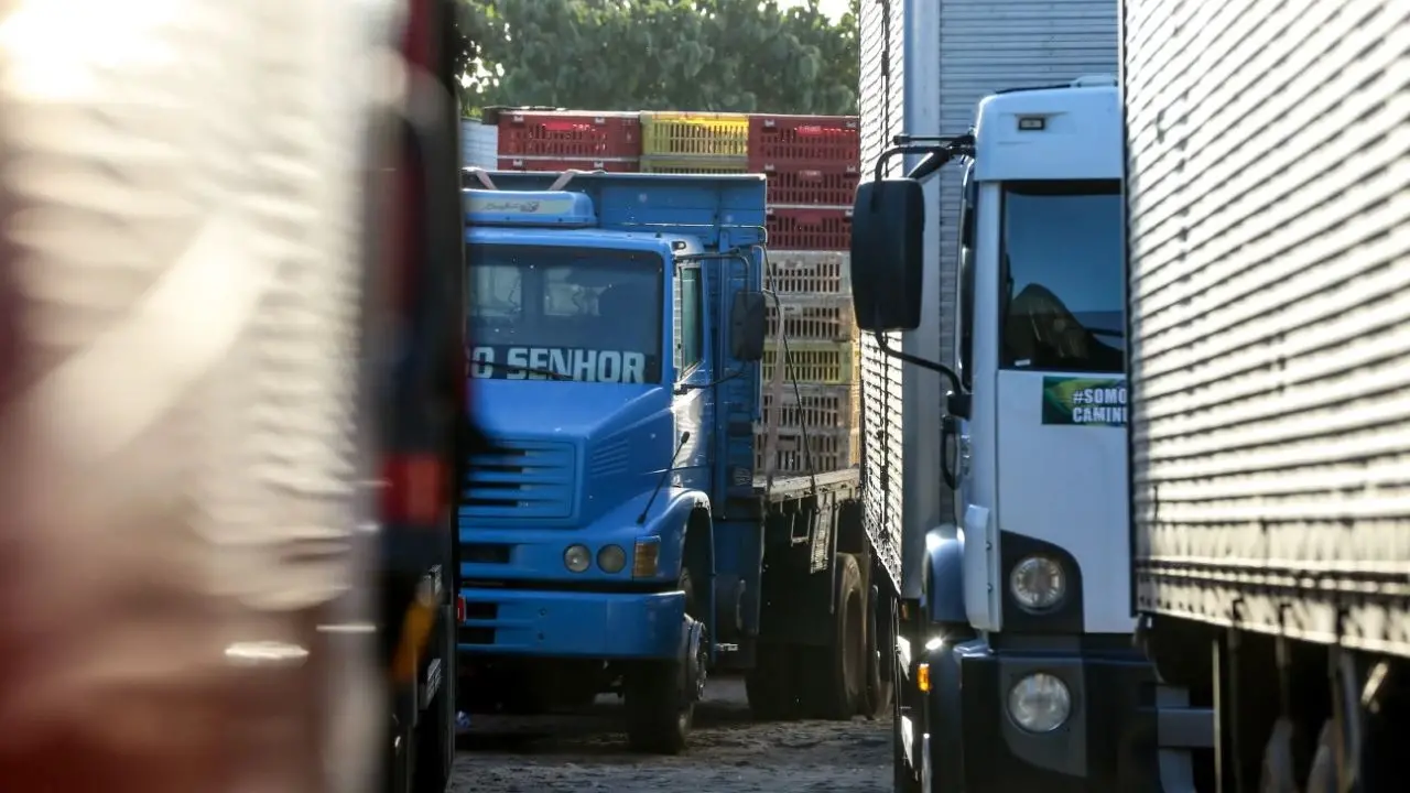 Foto que contém caminhões de carga