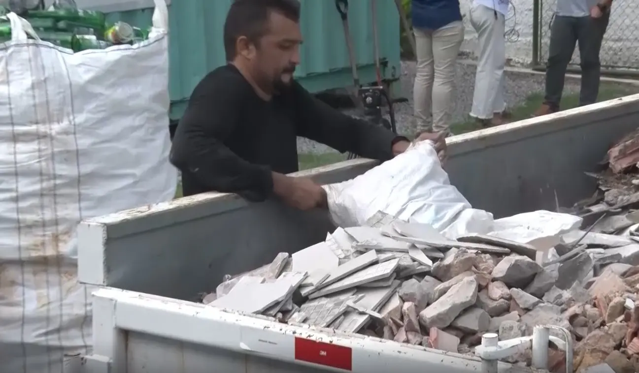 Homem retira entulho de caminhão