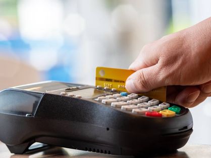 Mão passando cartão de crédito em maquineta