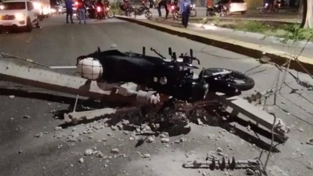 Imagem mostra motocicleta sob um poste de energia após condutor colidir contra a estrutura, na noite de 3 de outubro de 2023, na Av. Leste-Oeste em Fortaleza.