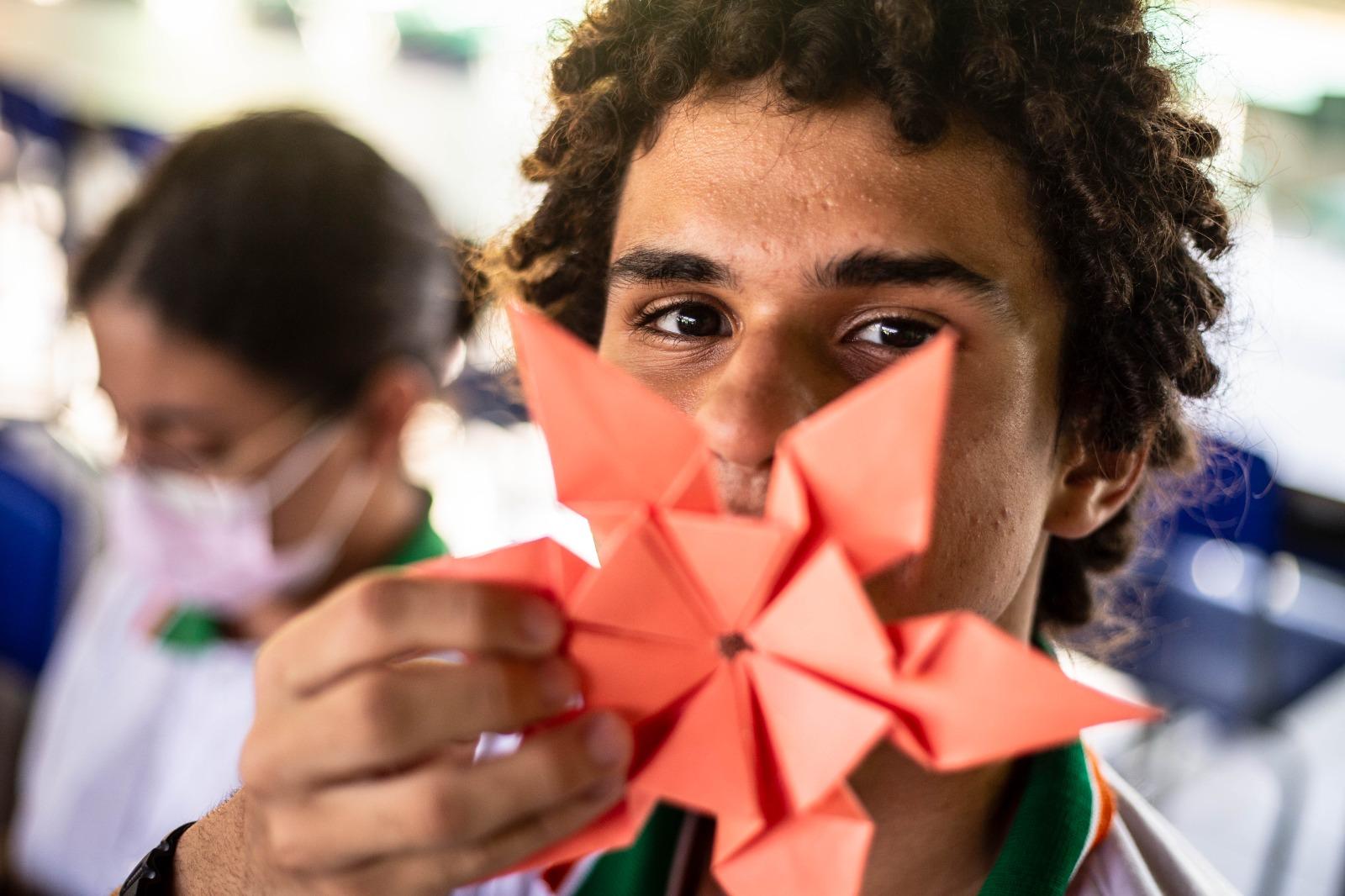 Alunos mostrando trabalho de artes fora da sala de aula
