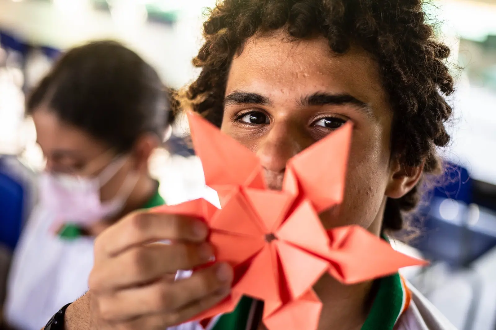 Alunos mostrando trabalho de artes fora da sala de aula