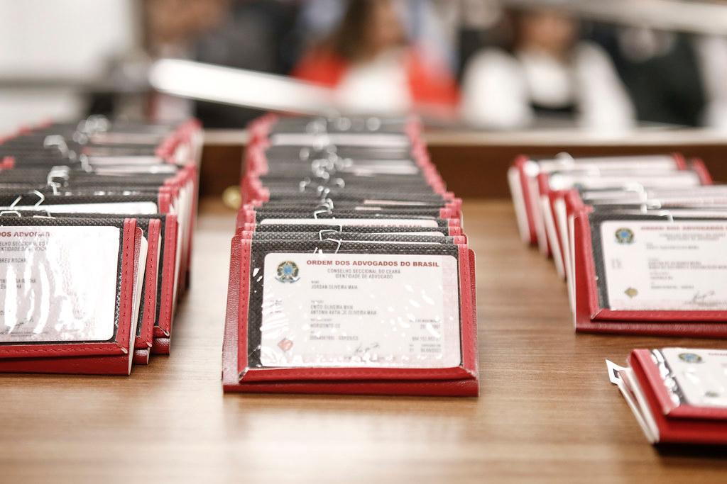 Carteiras de novos advogados sobre a mesa do auditório da OAB Ceará