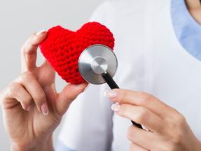 Médica examina coração de crochê