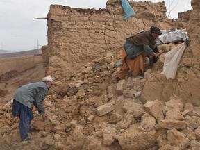 Grupos de homens usam pás entre os escombros das casas para achar sobreviventes