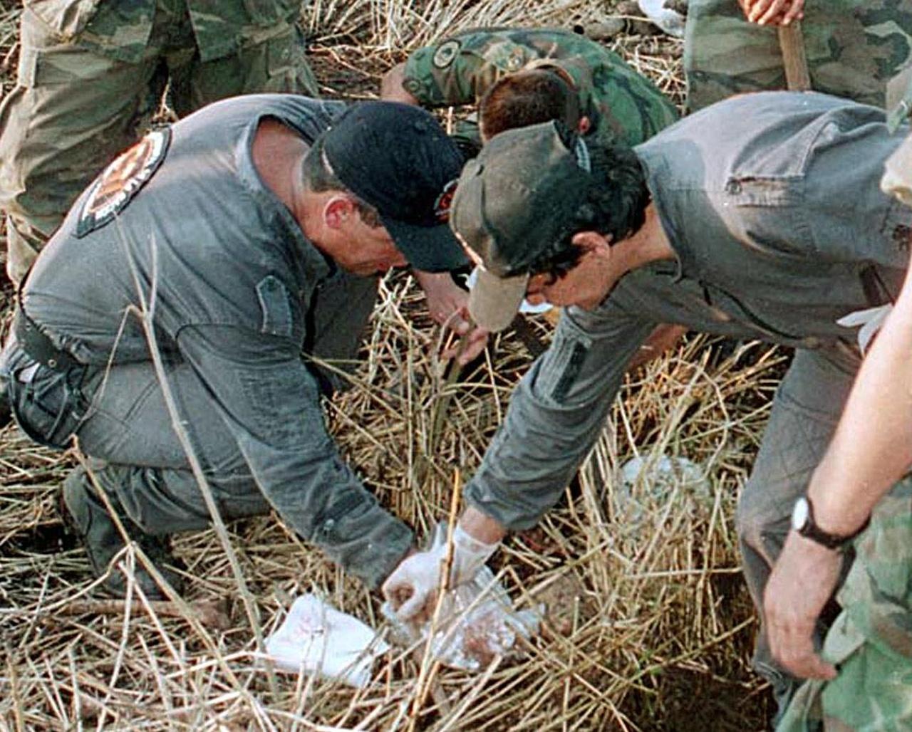 Membros da Fiscalia recolhem um dos esqueletos de algumas das cento e quarenta crianças assassinadas por Luis Alfredo Garavito em outubro de 1998, em Pereira 320 Kms. a oeste de Bogotá, Colômbia.