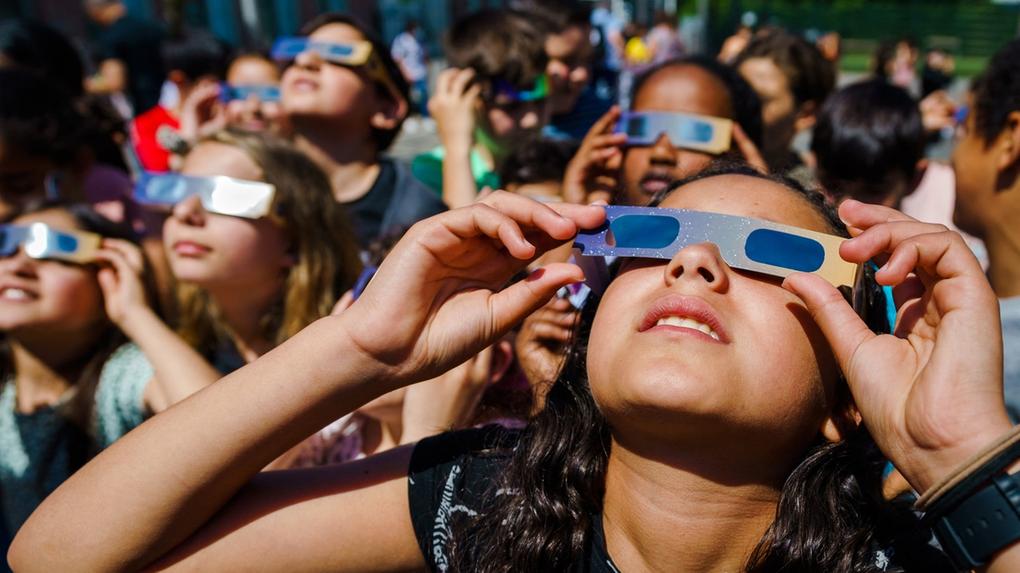 Crianças com óculos especiais para observar eclipse