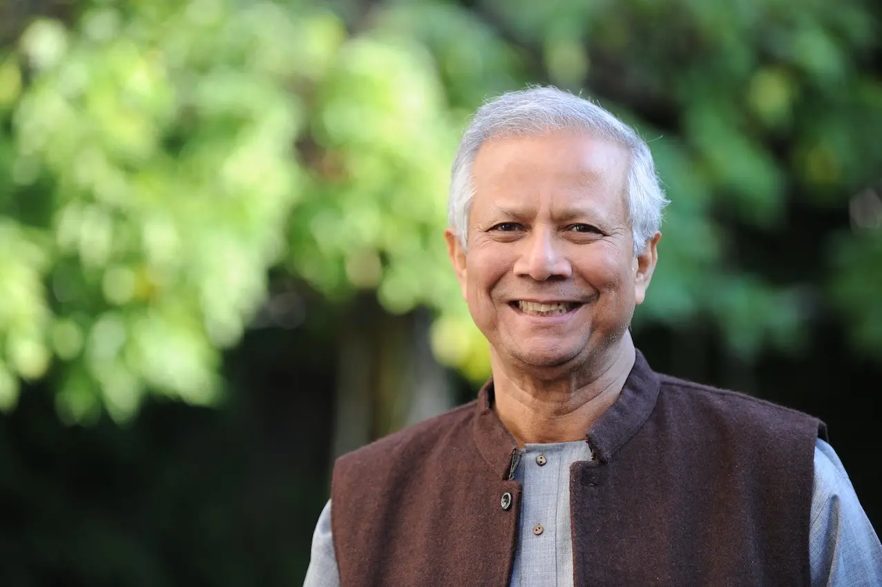 Foto de perfil de Yunus mostra o economista numa área verde, sorrindo