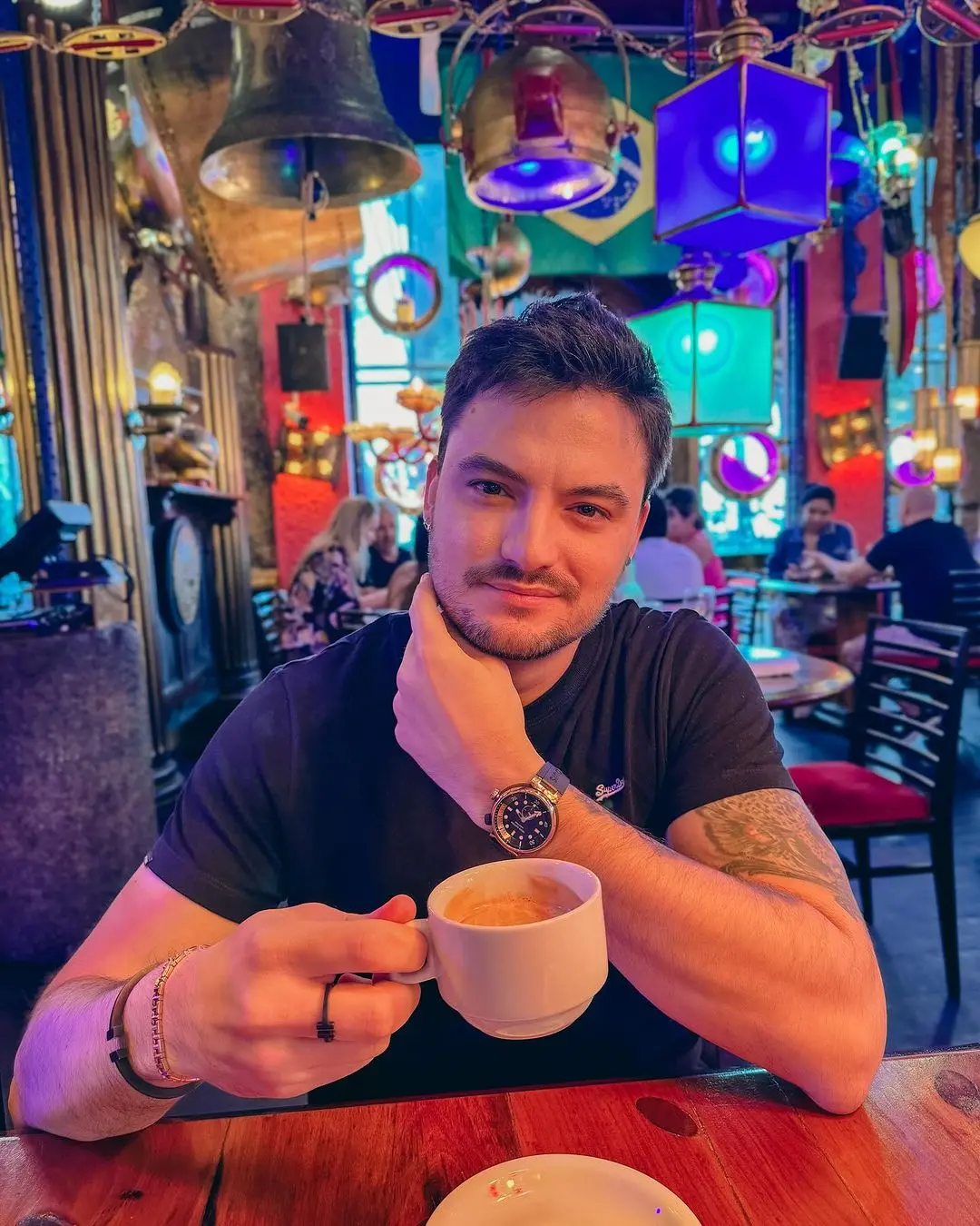 felipe neto segurando xícara em um café