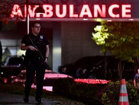 Imagem mostra um policial armado guarda a entrada da ambulância do Central Maine Medical Center em Lewiston, Maine, no início de 26 de outubro de 2023.