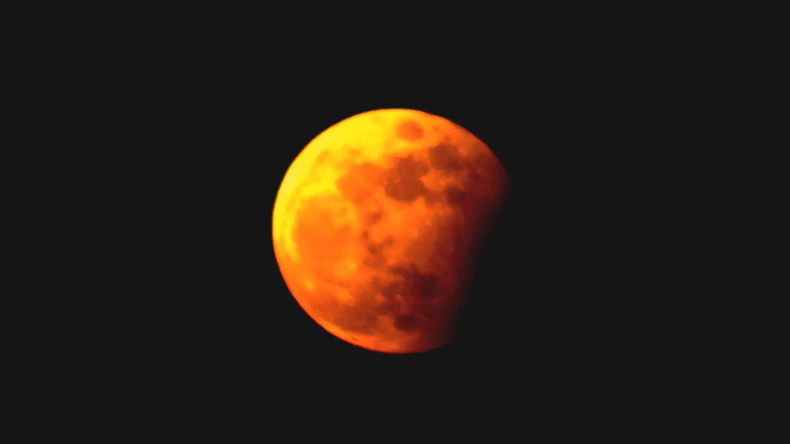 Imagem mostra a Lua coberta pela sombra da Terra