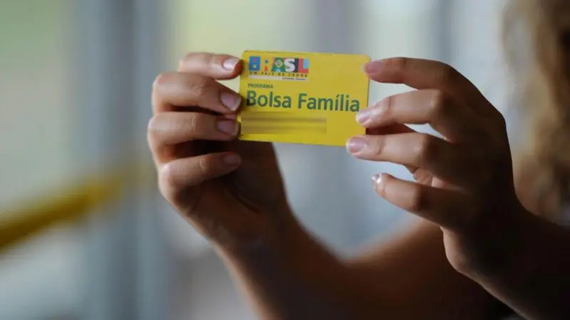 Imagem de uma mulher segurando o cartão do projeto