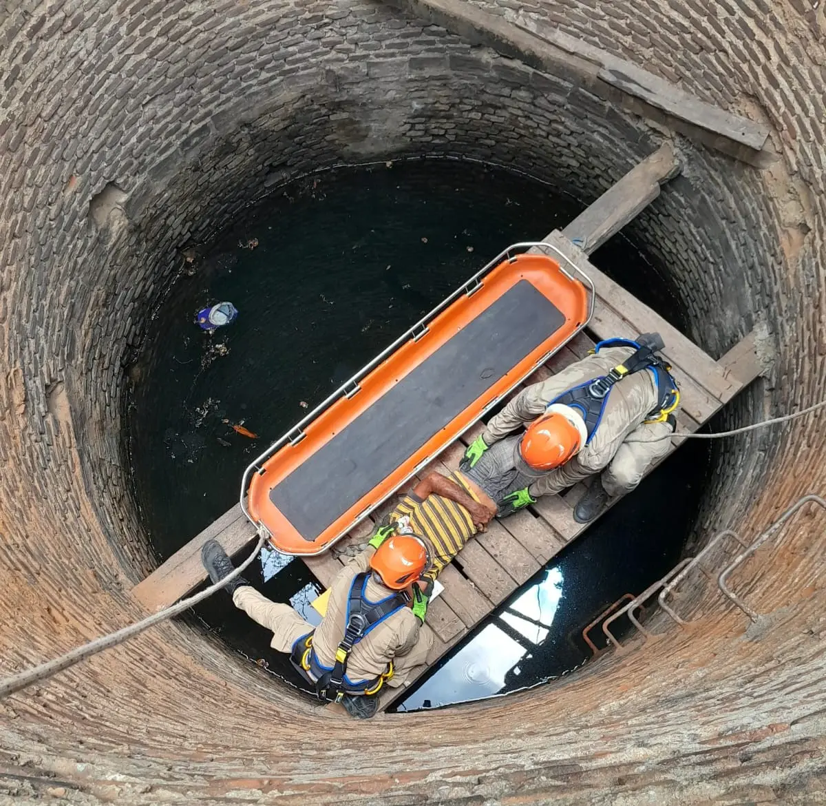 foto de resgate do corpo de bombeiros a homem que caiu em cacimca