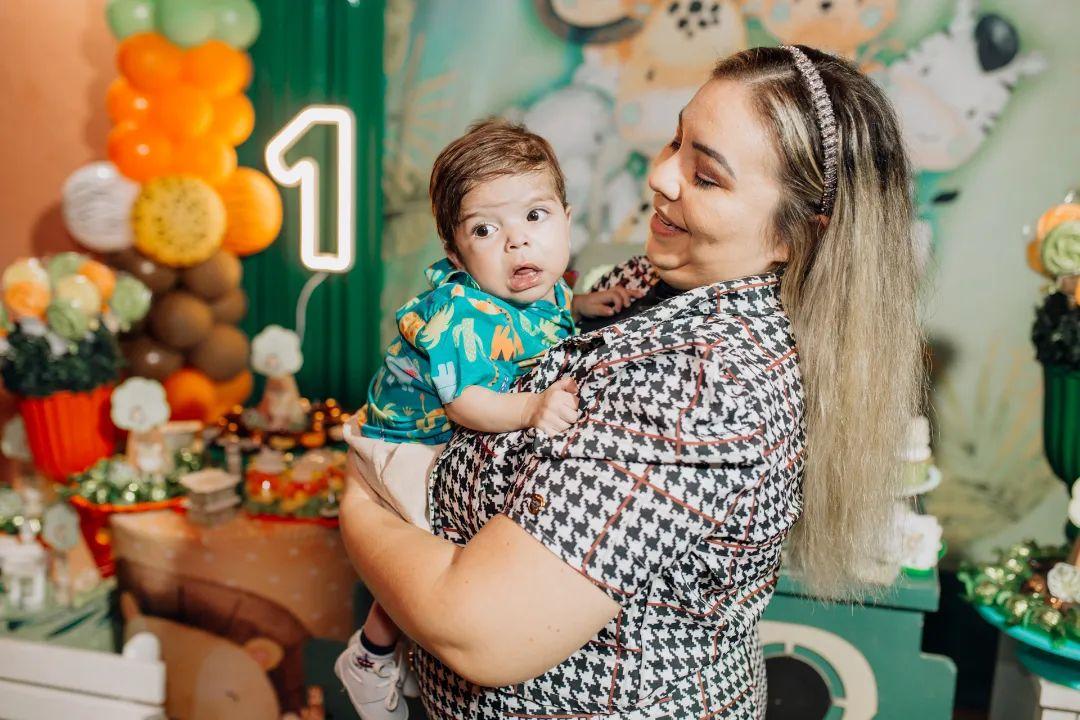 bebê milagre de caucaia nos braços da mãe em festa de aniversário