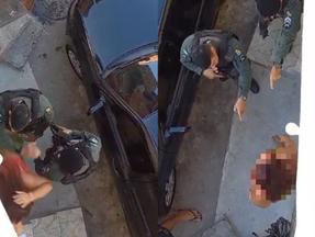 print de vídeo onde policiais abordam mulher e um deles empurra ela