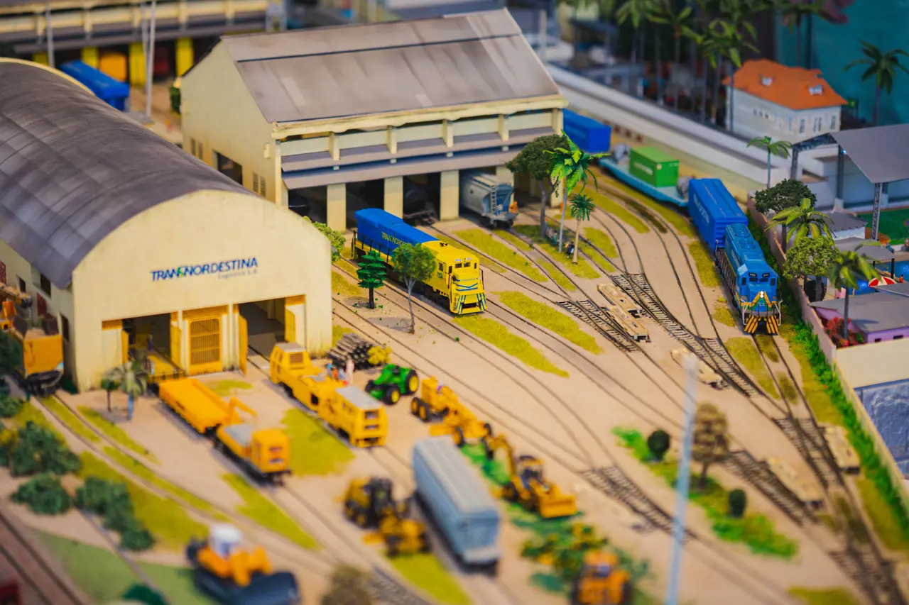 Museu Ferroviário exibe miniatura da malha férrea com trens, galpões, tratores, grandes faixas de terra, areia e grama