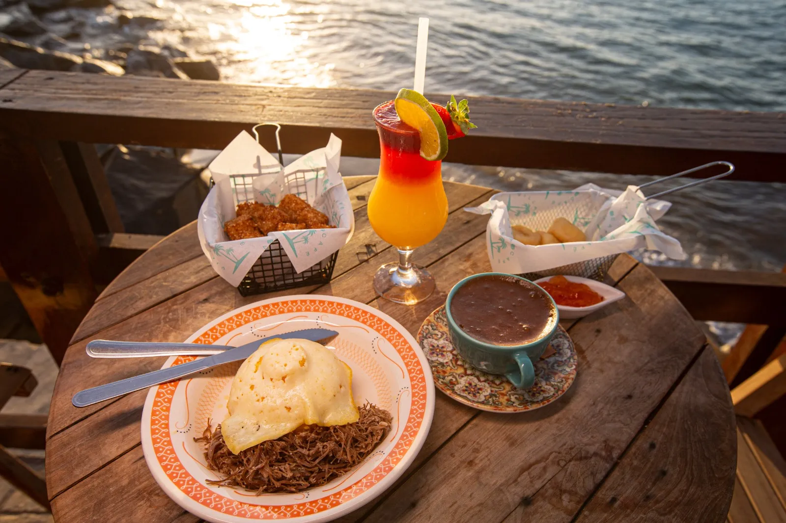 Espaço conta com mesas no calçadão e pertinho do mar. Na foto, cuscuz, dadinho com carne de sol, cappuccino cremoso, suco Villa e pães de queijo