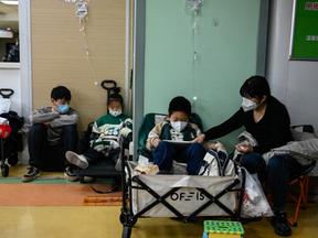 Pessoas de máscara em busca de atendimento médico na China