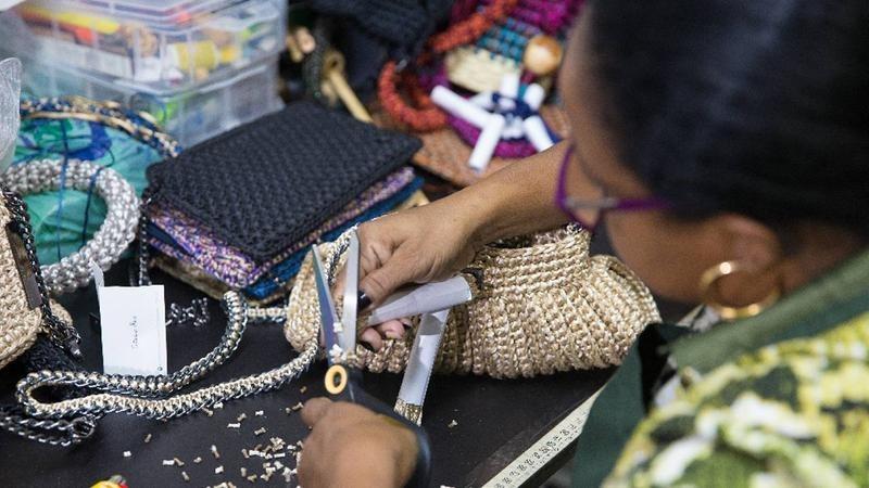 Mulher empreendedora trabalhando na confecção de uma bolsa feminina