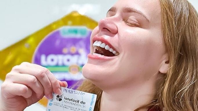 Foto de Paulinha Leite com um bilhete de loteria