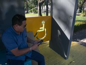 homem carregando celular em USB de nova parada de Ônibus em Fortaleza
