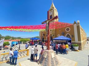 Entrada de igreja enfeitada para festa de santa luzia, com população