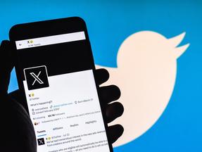 Foco seletivo da nova conta oficial do Twitter 'X' em uma tela de celular. Elon Musk substitui o icônico símbolo do pássaro azul