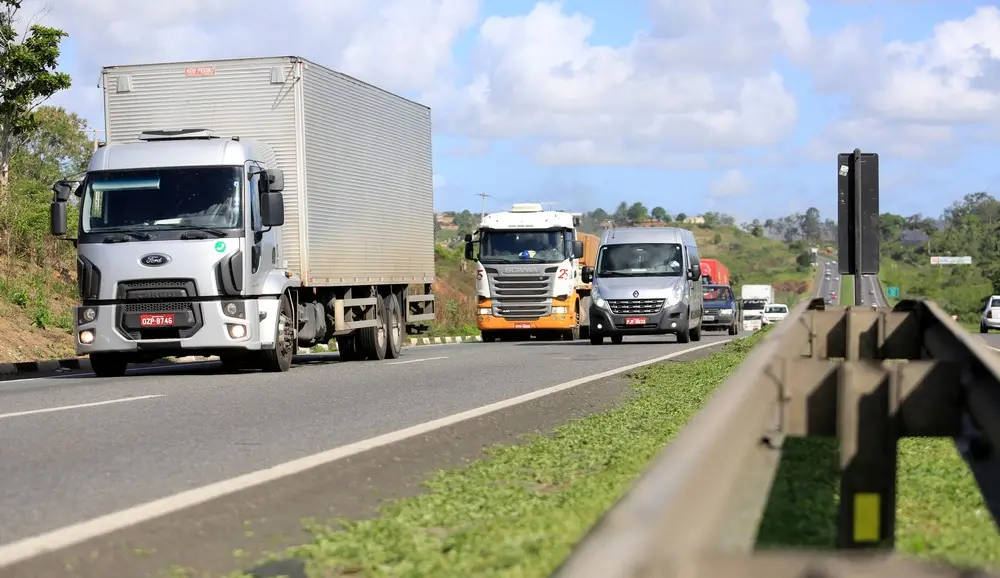Caminhões trafegando por uma estrada brasileira