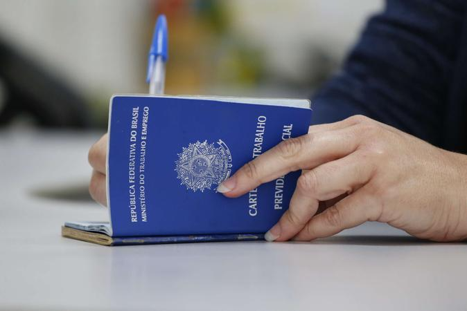 foto de pessoa assinando carteira de trabalho