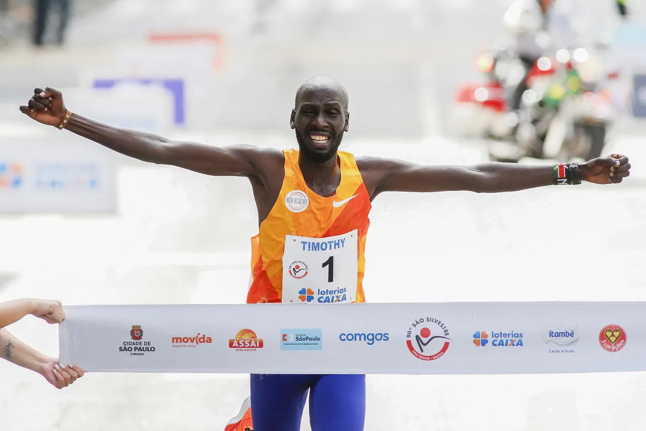 O corredor queniano Timothy Kiplagat cruza a linha de chegada para vencer a 98ª corrida internacional de 15 km de São Silvestre em São Paulo