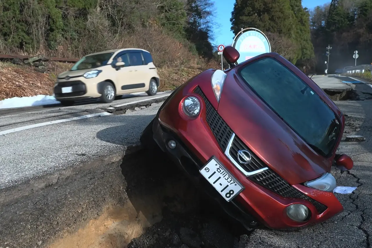 Esta captura de tela de um vídeo da AFPTV feito em 2 de janeiro de 2024 mostra um carro danificado deixado na beira de uma estrada em Wajima, província de Ishikawa, um dia depois que um grande terremoto de magnitude 7,5 atingiu a região de Noto, na província de Ishikawa. Japão suspende alerta de tsunami após terremoto de grande magnitude; veja imagens dos estragos