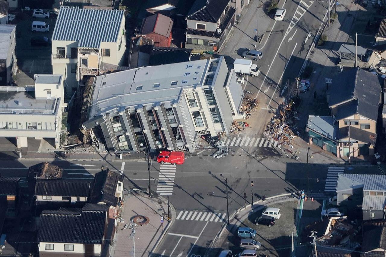 Esta foto aérea fornecida pela Jiji Press mostra um veículo de resgate (C) estacionado próximo a um prédio de sete andares que caiu em Wajima, província de Ishikawa, em 2 de janeiro de 2024, um dia depois que um grande terremoto de magnitude 7,5 atingiu a região de Noto em Ishikawa prefeitura. Japão suspende alerta de tsunami após terremoto de grande magnitude; veja imagens dos estragos