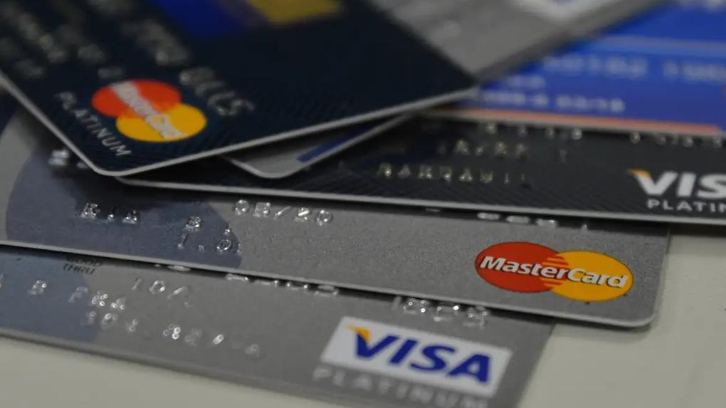 Imagem mostra diversos cartões de créditos dispostos um por cima do outro sobre fundo branco. Cartão de crédito: Saiba o que muda para quem atrasa ou não paga valor total da fatura