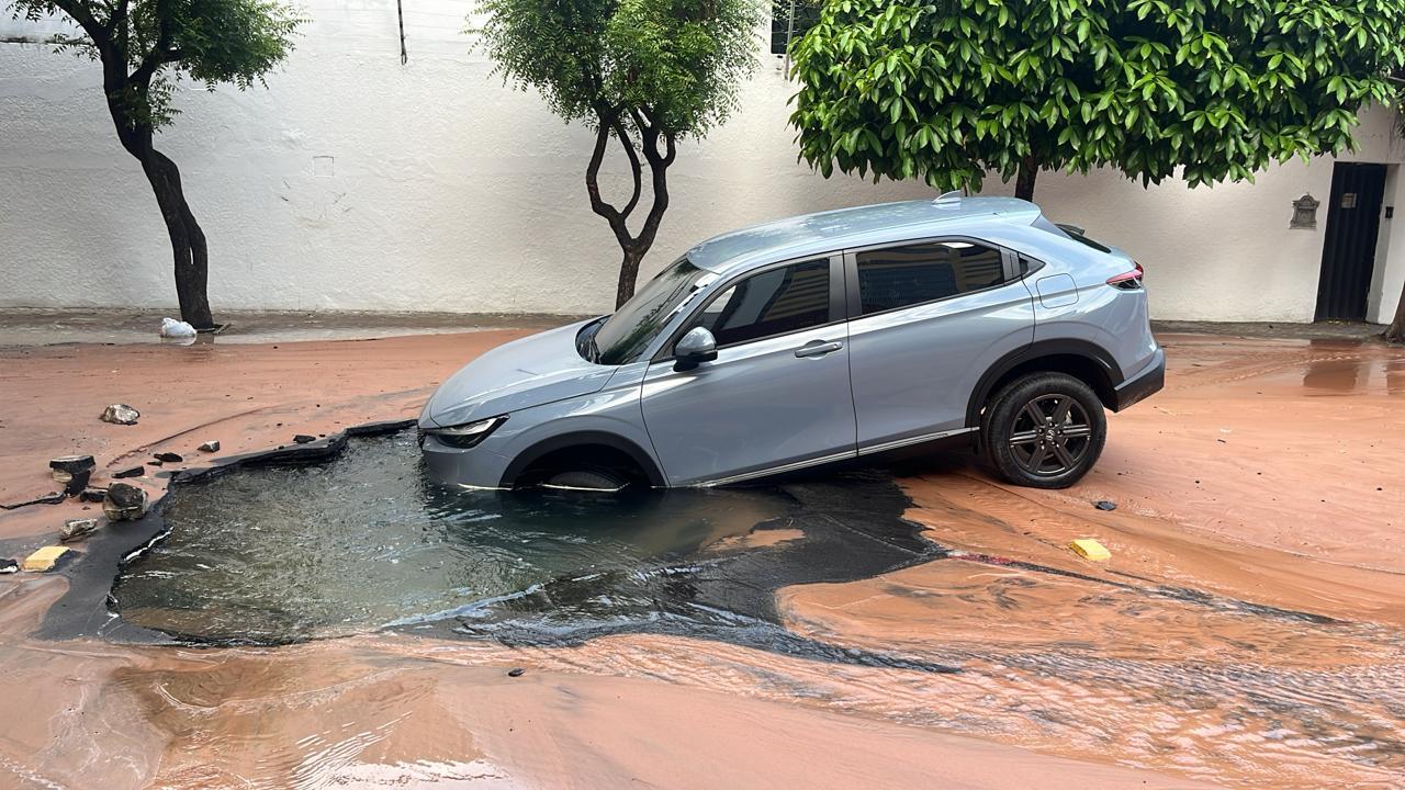 Imagem mostra carro caído dentro de buraco que se abriu na rua Barbosa de Freitas, na manhã de 15 de janeiro de 2024, em Fortaleza. Asfalto alagado cede e carro cai em buraco em bairro nobre de Fortaleza