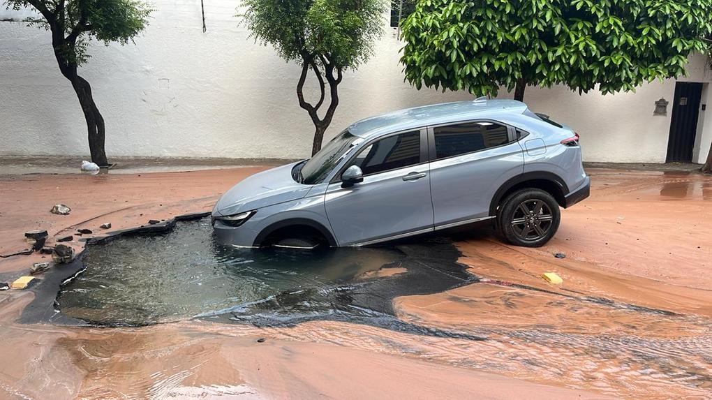 Imagem mostra carro caído dentro de buraco que se abriu na rua Barbosa de Freitas, na manhã de 15 de janeiro de 2024, em Fortaleza. Asfalto alagado cede e carro cai em buraco em bairro nobre de Fortaleza