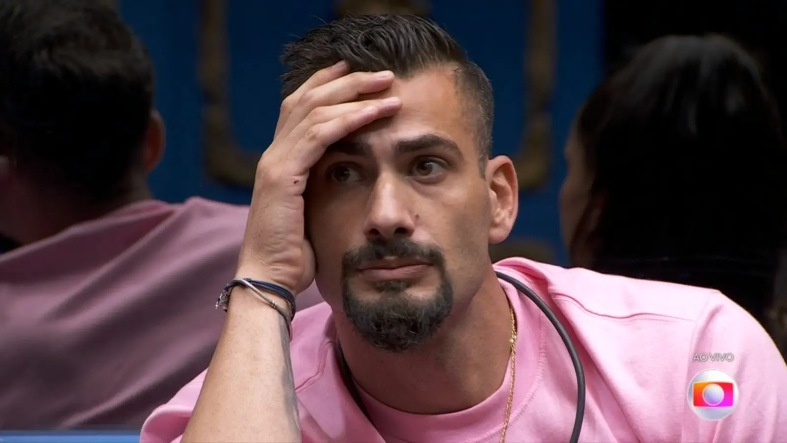 Foto de Nizam, do BBB 24, de camisa rosa na cozinha